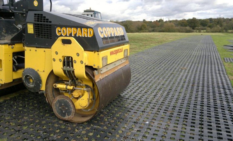 PERFO geogrid tiles are rolled into the grass. The no dig solution